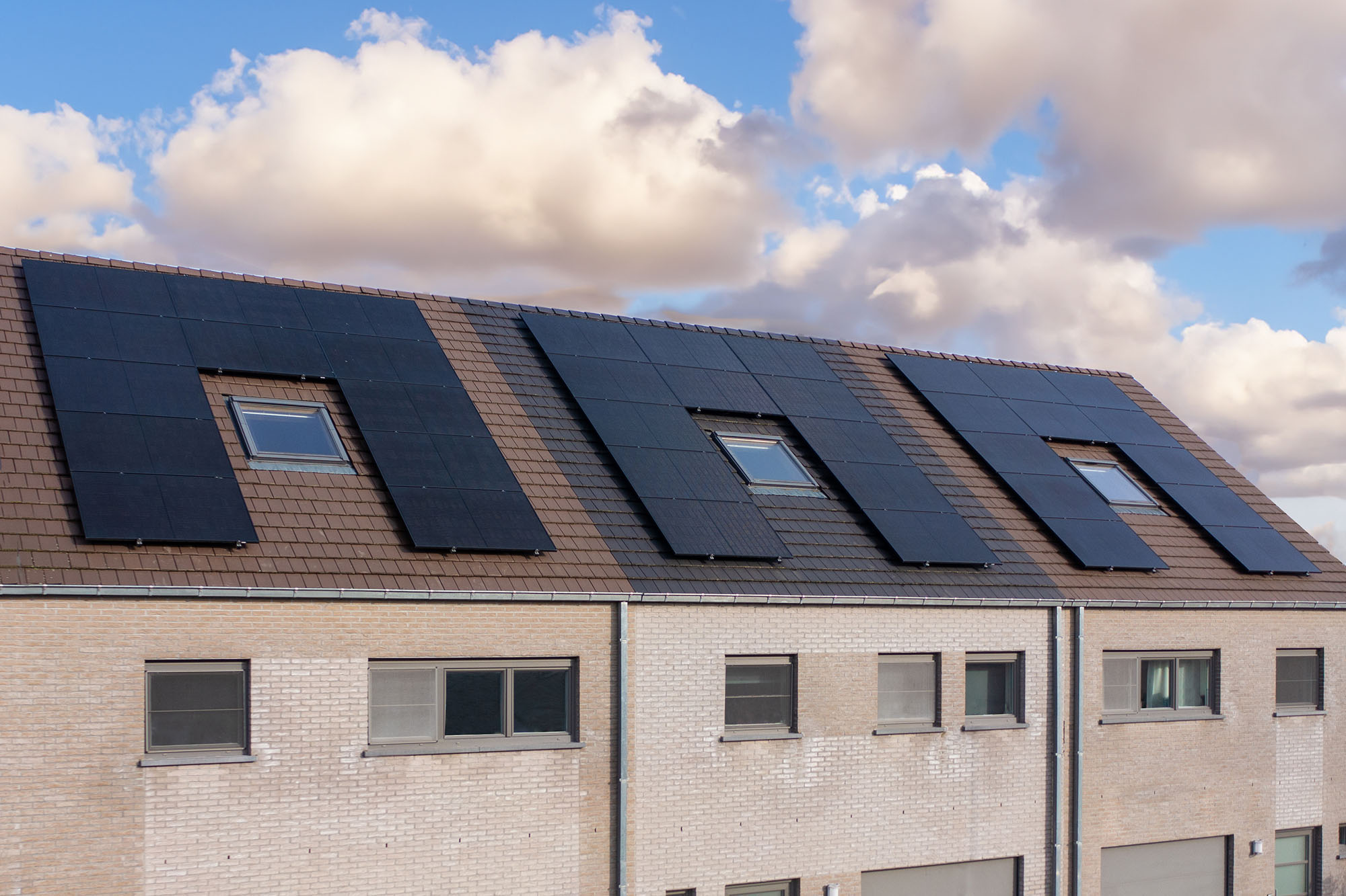 Drie rijwoningen waarvan de daken bekleed zijn met zonnepanelen geplaatst door Solar Engineering